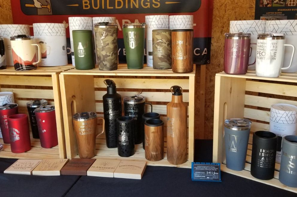 Photo of products from Sasshole Designs, a vendor of the Old Hickory Waterside Markets, including tumblers propped against boxen crates.