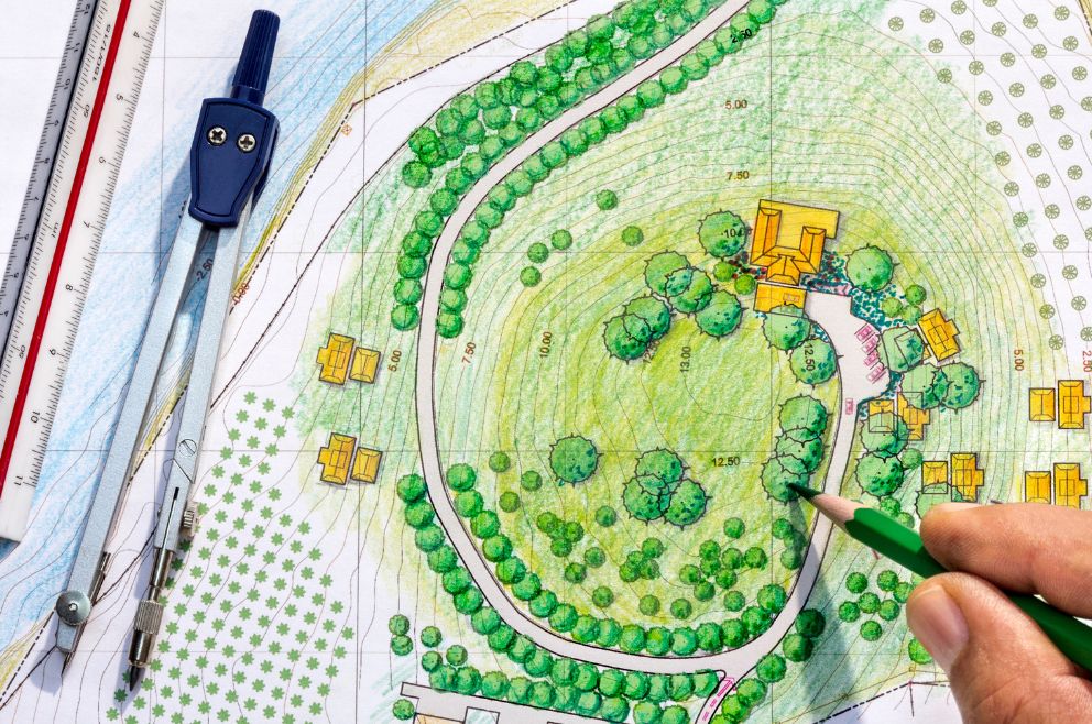 Image of a man colouring a landscape design with pencil crayon.