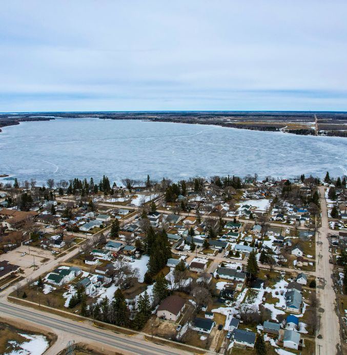 Aerial view of the Town of Lac du Bonnet showing houses, stores, and the Winnipeg River.