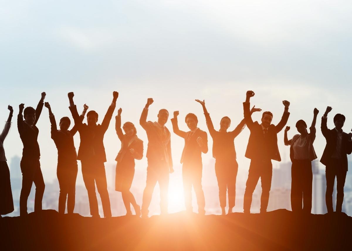 Photo of a group of people cheering atop a hill.
